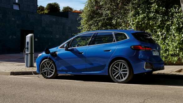 BMW serije 2 Active Tourer 230e plug-in hibrid U06 2021 M Portimao Blue metalik u pogledu s boka parkiranog na stanici za punjenje