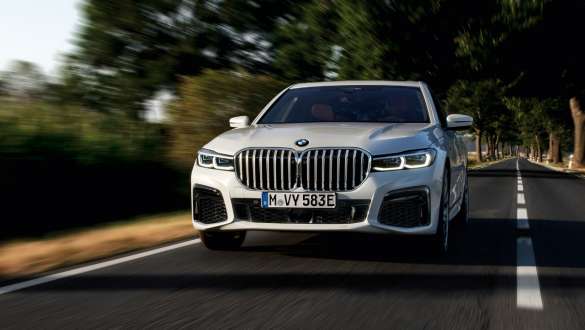 BMW 745e limuzina plug-in hybrid G11 G12 Mineral White pogled sprijeda BMW 745e limuzina plug-in hybrid G11 G12 Mineral White pogled sprijeda u vožnji na cesti