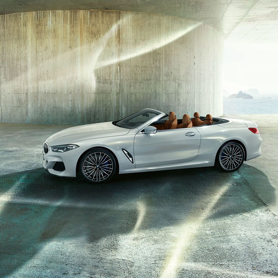 BMW M850i xDrive u Mineral White metalik boji, prikaz s bočne strane s otvorenim mekim krovom. BMW M850i xDrive u Mineral White metalik boji, prikaz s bočne strane s otvorenim mekim krovom.