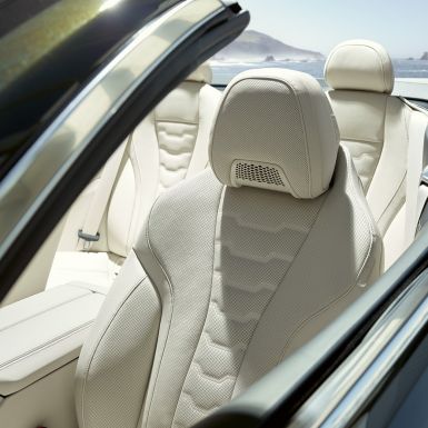 BMW M850i xDrive Cabrio, višenamjenska sjedala za vozača i suvozača. BMW M850i xDrive Cabrio u Dravit Grey metalik boji, sa spuštenim mekim krovom, unutrašnjost s višenamjenskim sjedalima u BMW Individual unutrašnjosti od 'Merino' kože u Ivory White boji.