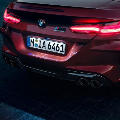 BMW M8 Competition Cabrio, detaljan prikaz stražnjeg kraja. BMW M8 Competition Cabrio u Motegi Red metalik boji, detaljan prikaz stražnjeg kraja sa stražnjim LED svjetlima i M8 Competition oznakom.