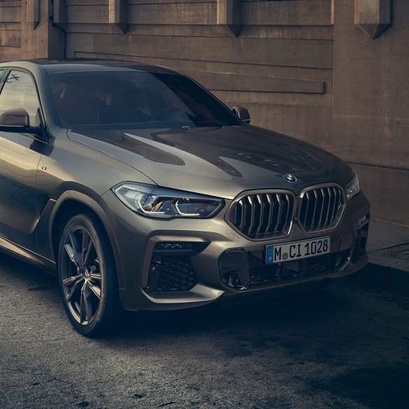 BMW X6 M50i s M TwinPower Turbo osmerocilindarskim benzinskim motorom Tročetvrtinski bočni prikaz BMW-a X6 M50i s M TwinPower Turbo osmerocilindarskim benzinskim motorom G06 Manhattan metalik boje