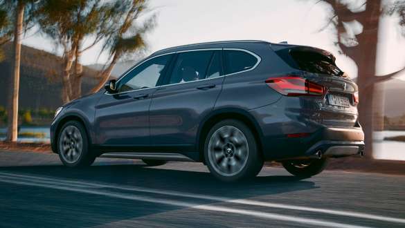 BMW X1 F48 tročetvrtinski pogled straga BMW X1 F48 LCI tročetvrtinski pogled straga u vožnji ispred planinskog krajolika