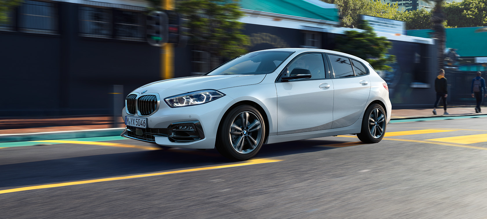 BMW serije 1 Model Sport Line, tročetvrtinski bočni prikaz. BMW serije 1 Model Sport Line u Mineral White metalik boji, tročetvrtinski bočni prikaz, u vožnji.