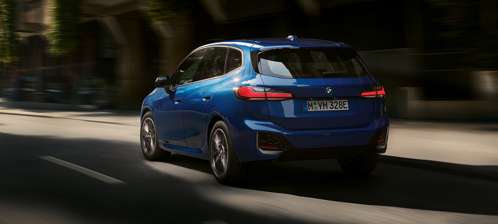 BMW serije 2 Active Tourer 230e plug-in hibrid U06 2021 M Portimao Blue metalik tročetvrtinski pogled straga u vožnji gradom