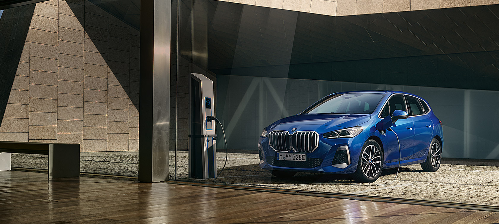 BMW serije 2 Active Tourer 230e plug-in hibrid U06 2021 M Portimao Blue metalik tročetvrtinski pogled sprijeda ispred punionice