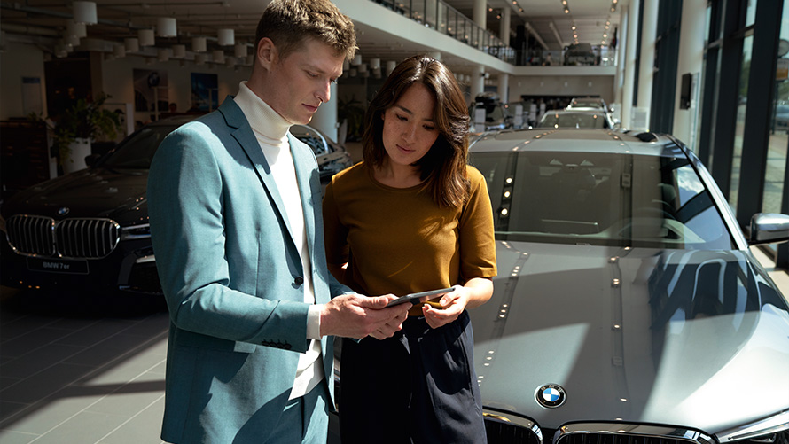 Zaposlenik BMW servisa razgovara sa klijenticom Zaposlenik BMW servisa razgovara sa klijenticom