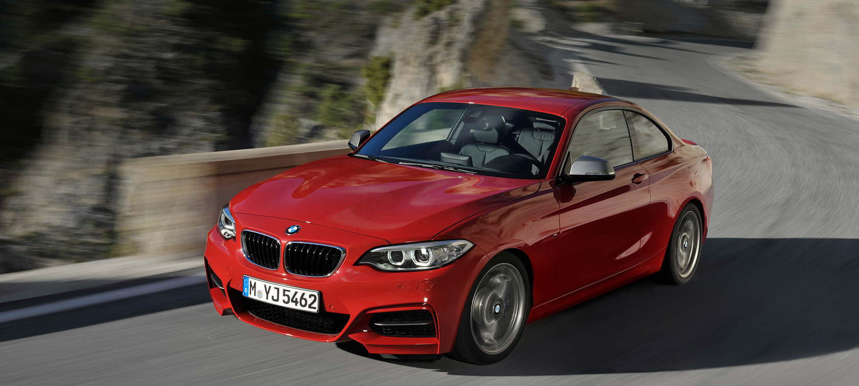 BMW serije 2 tročetvrtinski pogled sprijeda u vožnji cestom ispred krajolika BMW serije 2 BMW tročetvrtinski pogled sprijeda u vožnji cestom ispred krajolika