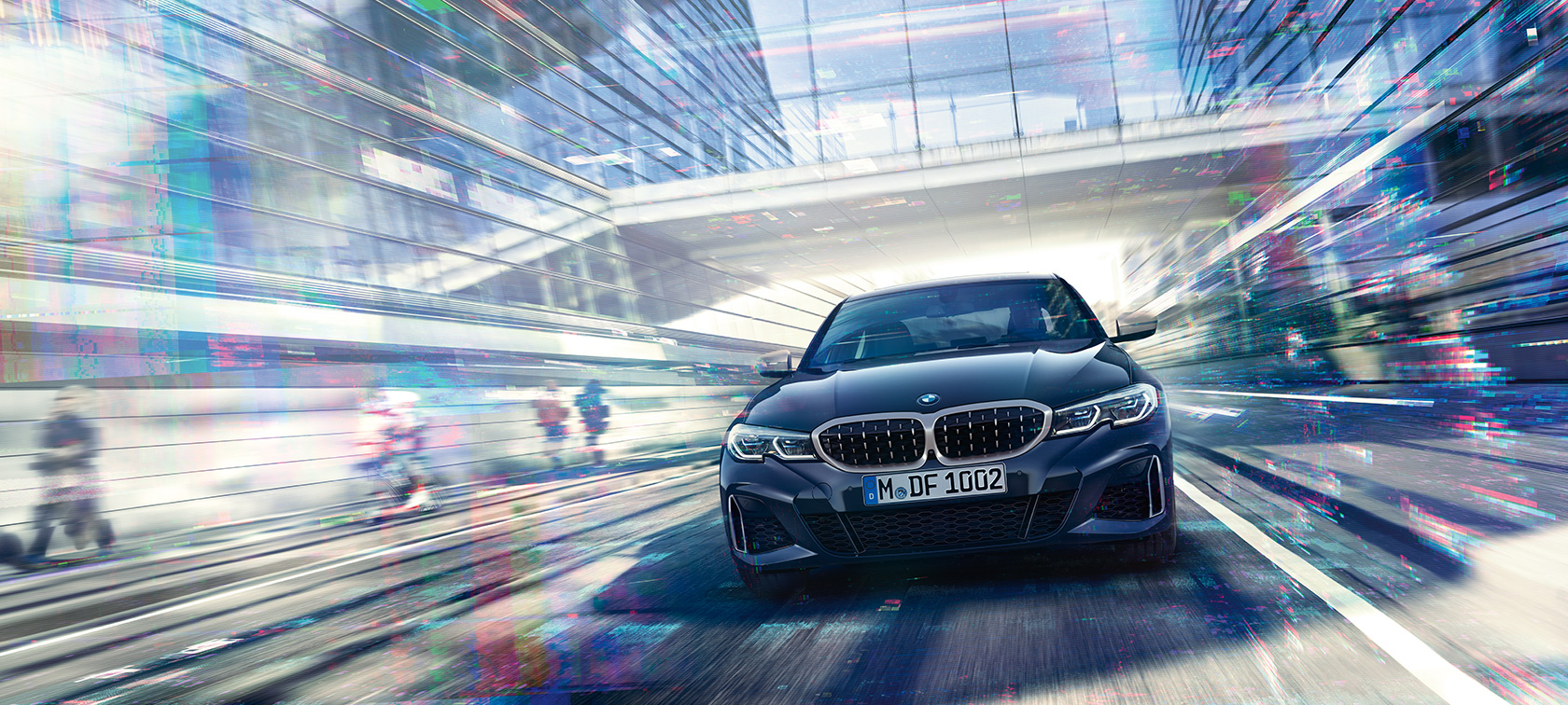 BMW serije 3 Limuzina, prednji prikaz BMW-a M340i xDrive. Prednji prikaz BMW-a M340i xDrive Limuzina između urbanih staklenih zgrada.
