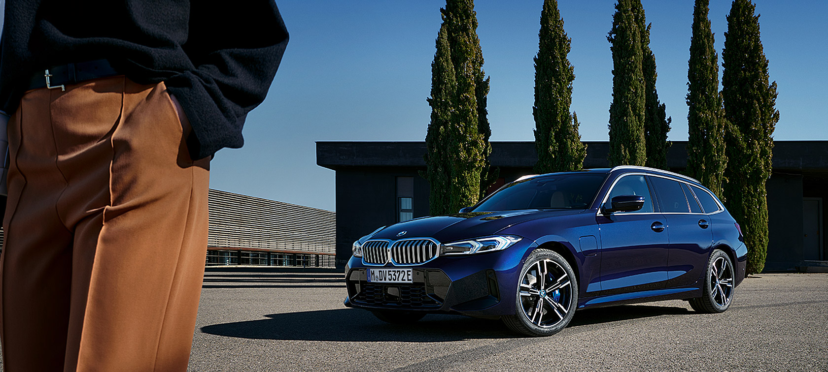 BMW serije 3 Touring LCI G21 Tansanit Blue II tročetvrtinski pogled sprijeda u mirovanju ispred drveća