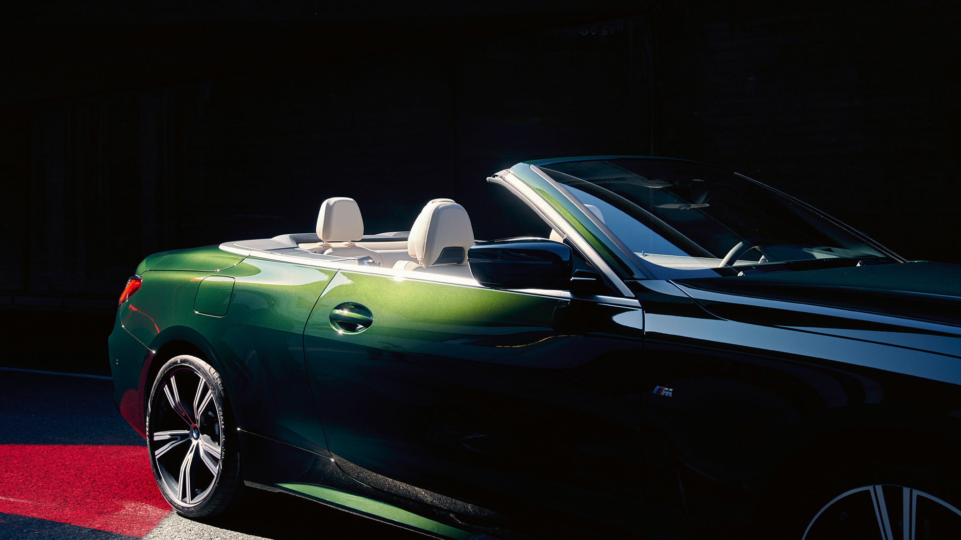 Tročetvrtinski prednji prikaz BMW serije 4 Cabrio G23 2020 u vožnji BMW serije 4 Cabrio G23 2020 Sanremo Green metalik tročetvrtinski stražnji prikaz u pokretu