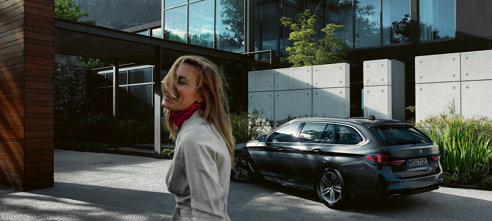 Žena ispred parkiranog BMW-a serije 5 Touring G31 BMW serije 5 Touring G31 Facelift 2020 žena ispred parkiranog BMW-a