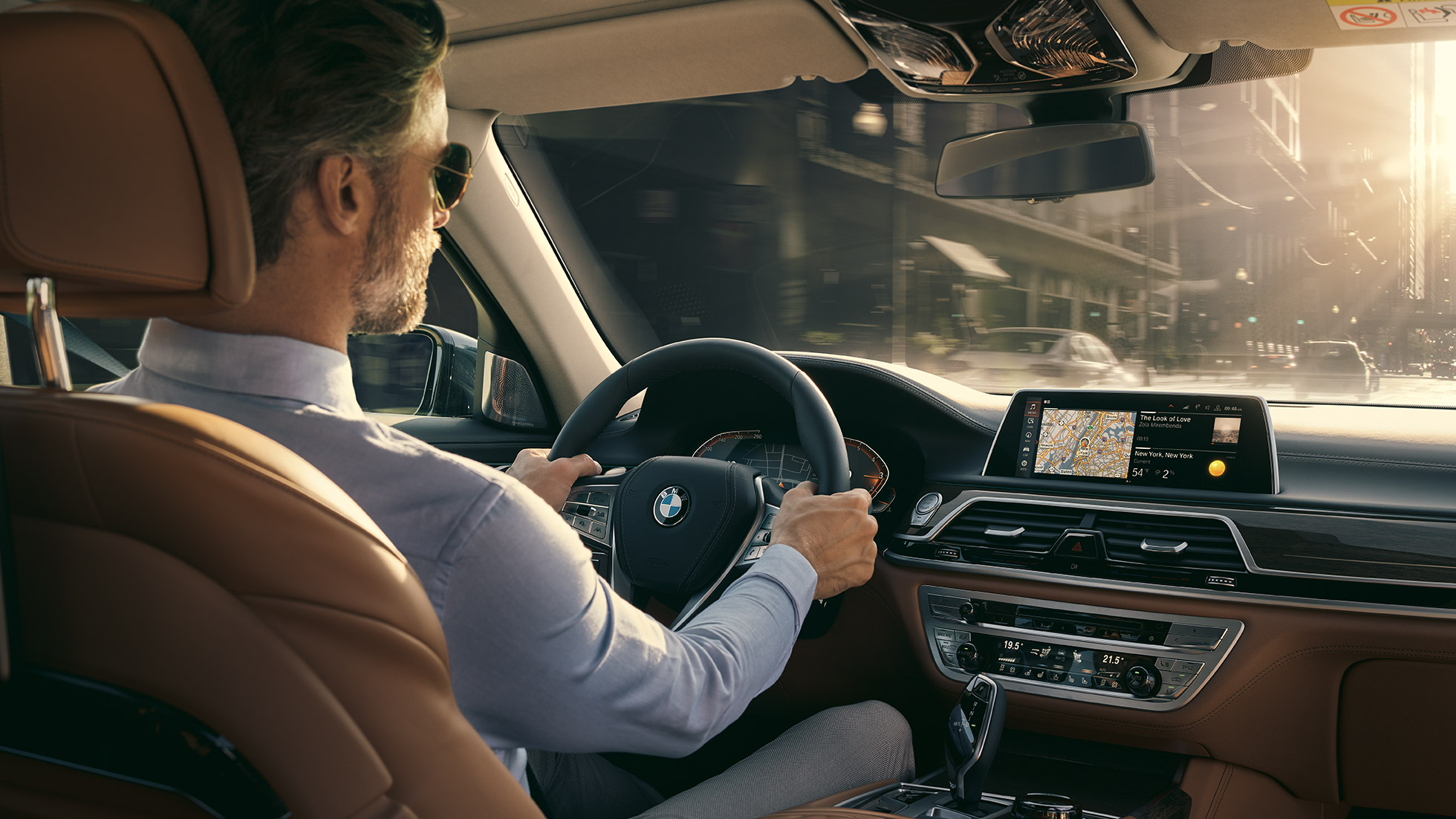 Connectivity značajke BMW-a serije 7 Limuzina BMW serije 7 Limuzina: čovjek sjedi u BMW-u i koristi Connectivity značajke