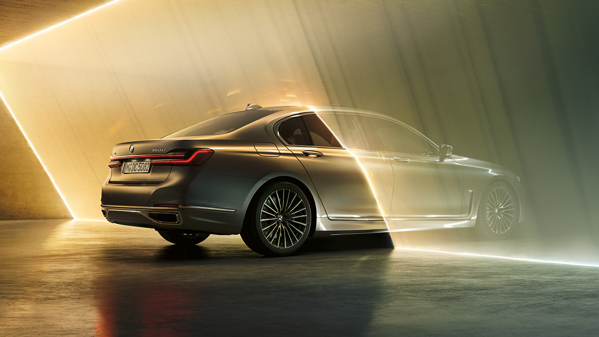 BMW serije 7 Limuzina u Bernina Grey boji karoserije BMW serije 7 Llimuzina Bernina Grey boje karoserije u tročetvrtinskom prednjem prikazu okružen svjetlosnim snopom