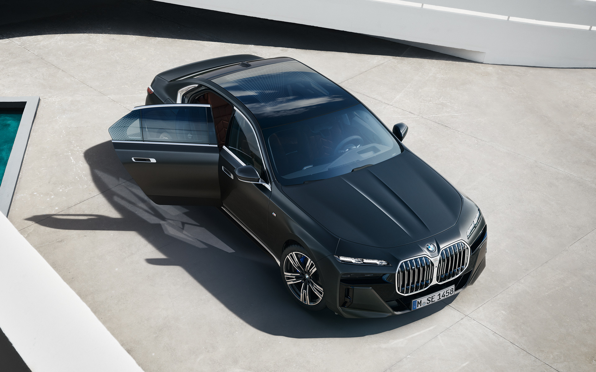 Pogled iz ptičje perspektive BMW serije 7 Limuzina G70 ICE 740i M sport paket BMW serije 7 Limuzina G70 ICE 740i M sport paket Frozen Deep Grey metalik pogled iz ptičje perspektive s otvorenim vozačevim vratima
