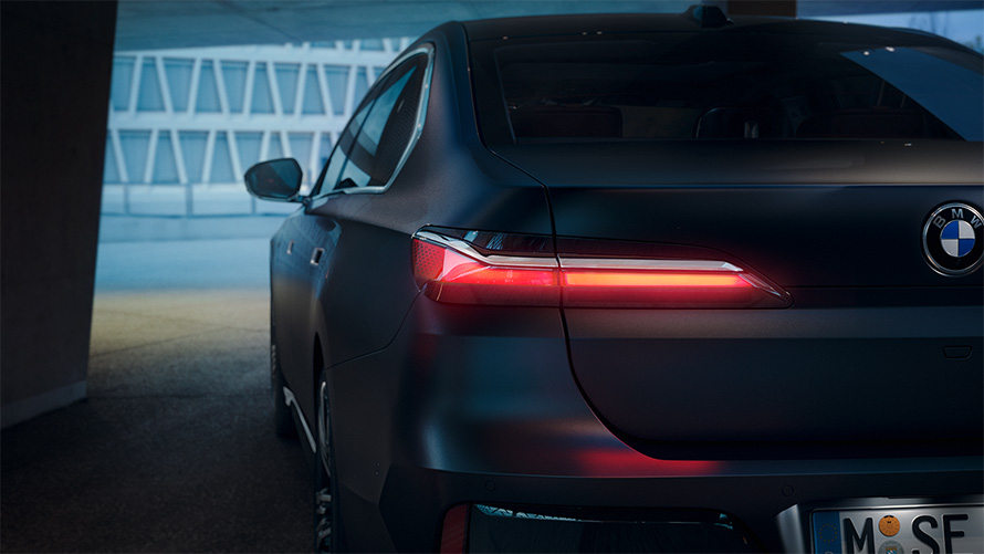 BMW serije 7 limuzina G70 ICE 740i M sport paket Frozen Deep Grey metalik stražnji pogled s upaljenim crvenim stražnjim svjetlom u tunelu