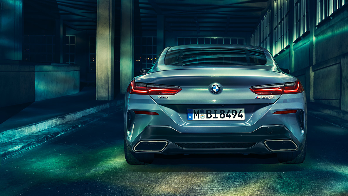 BMW serije 8 Coupé, prikaz stražnjeg kraja. Prikaz stražnjeg kraja BMW-a serije 8 Coupé noću u urbanom okruženju.