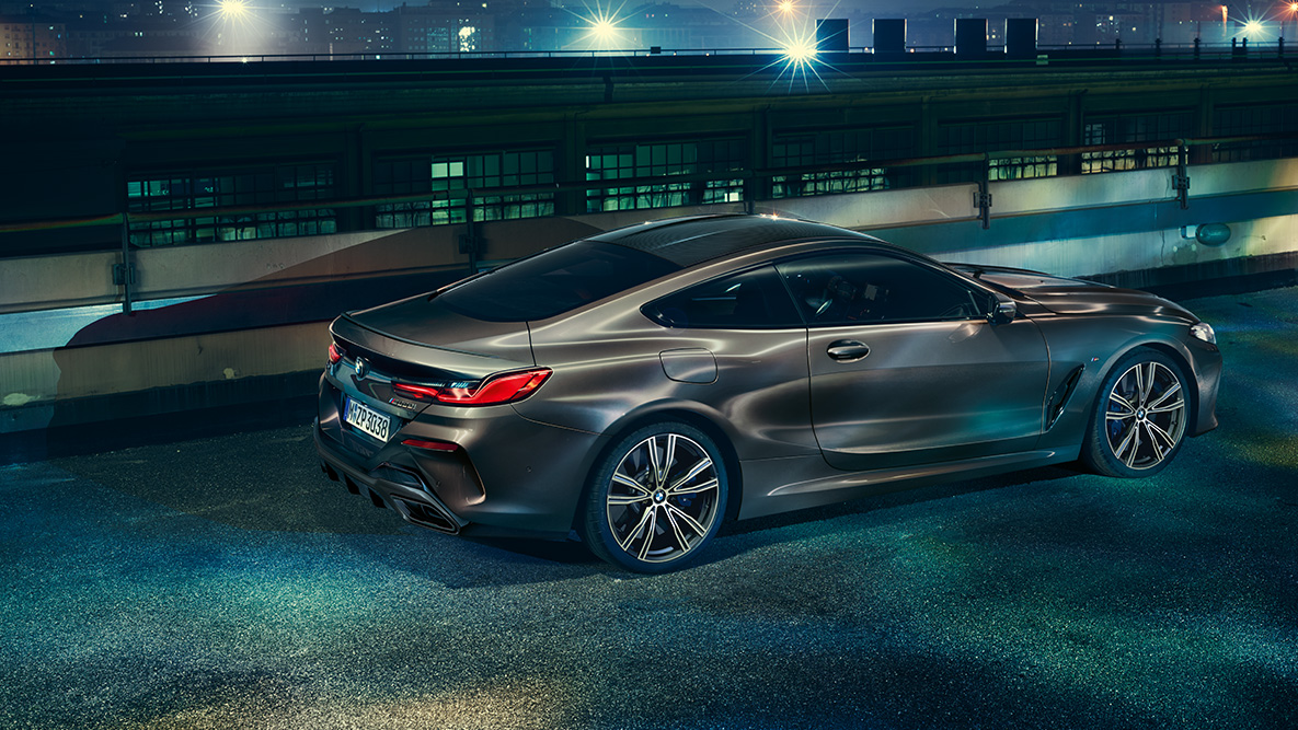 Prikaz BMW-a serije 8 Coupé. Bočni prikaz BMW-a serije 8 Coupé s BMW Individual opremom u urbanom okruženju noću.