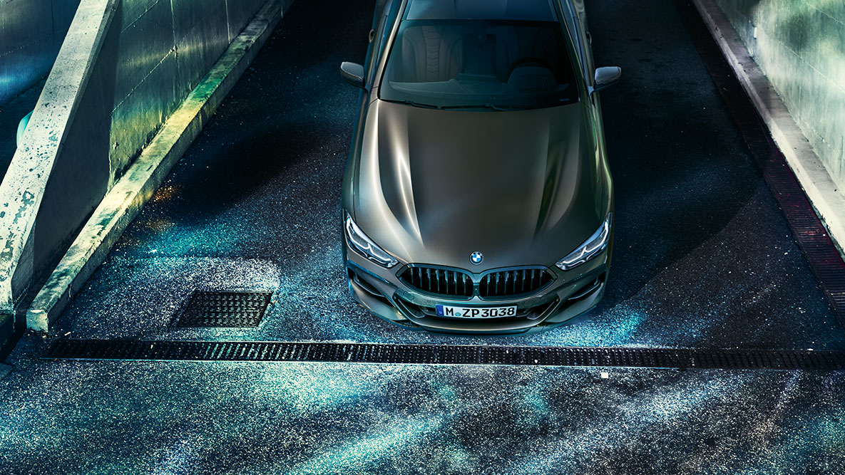 Prikaz BMW-a serije 8 Coupé. Prikaz prednjeg kraja BMW-a serije 8 Coupé s BMW Individual opremom u urbanom okruženju noću.