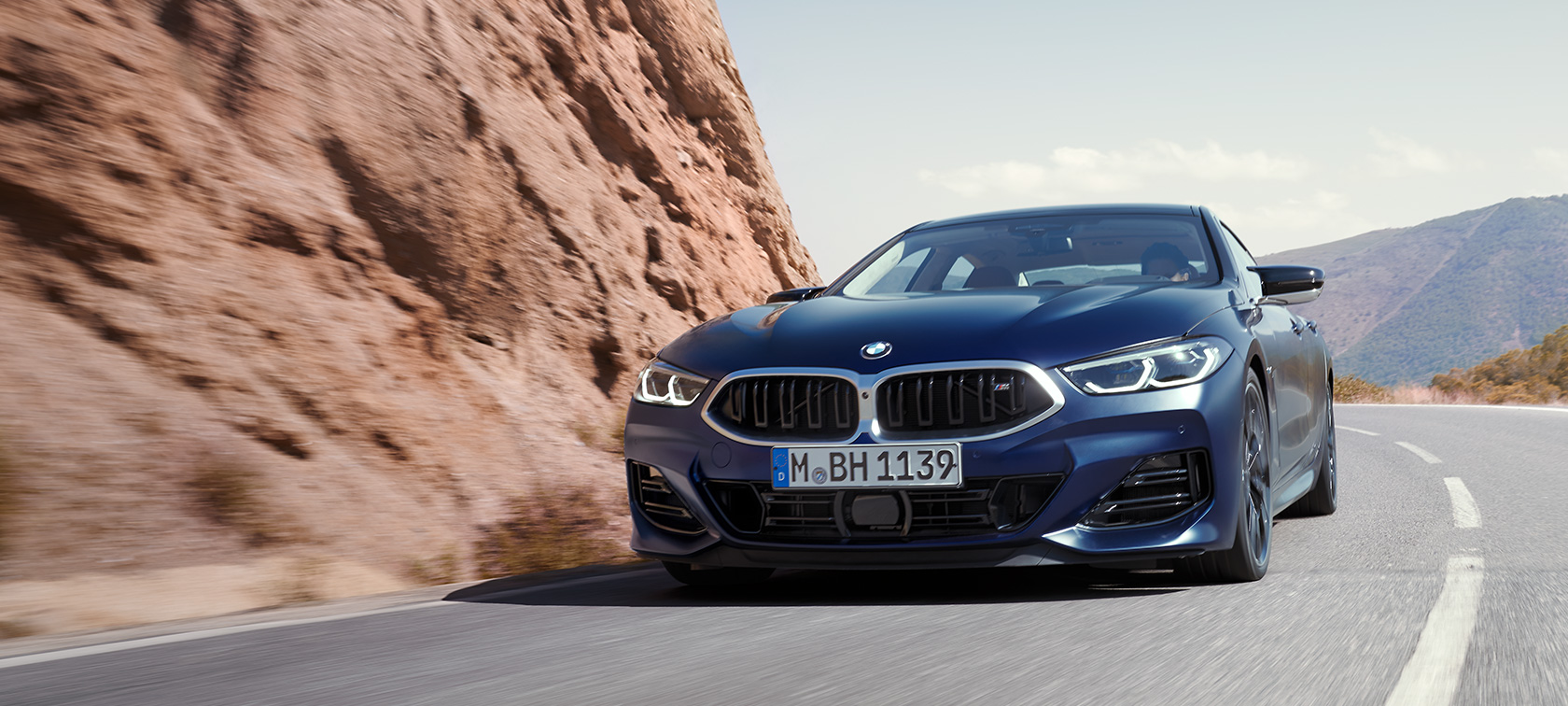 BMW serije 8 Gran Coupé G16 LCI Facelift 2022 BMW Individual Frozen Tanzanite Blue metalik tročetvrtinski pogled sprijeda u vožnji planinskom cestom