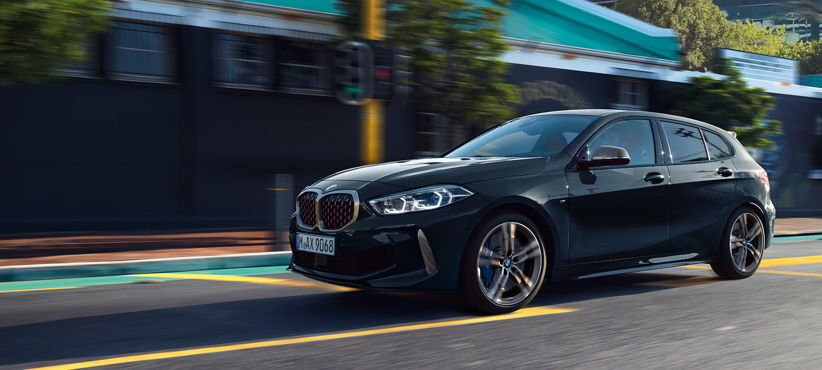 Potpuno novi BMW M135i xDrive Potpuno novi BMW M135i xDrive u Black Sapphire metalik boji, tročetvrtinski bočni prikaz prilikom vožnje.