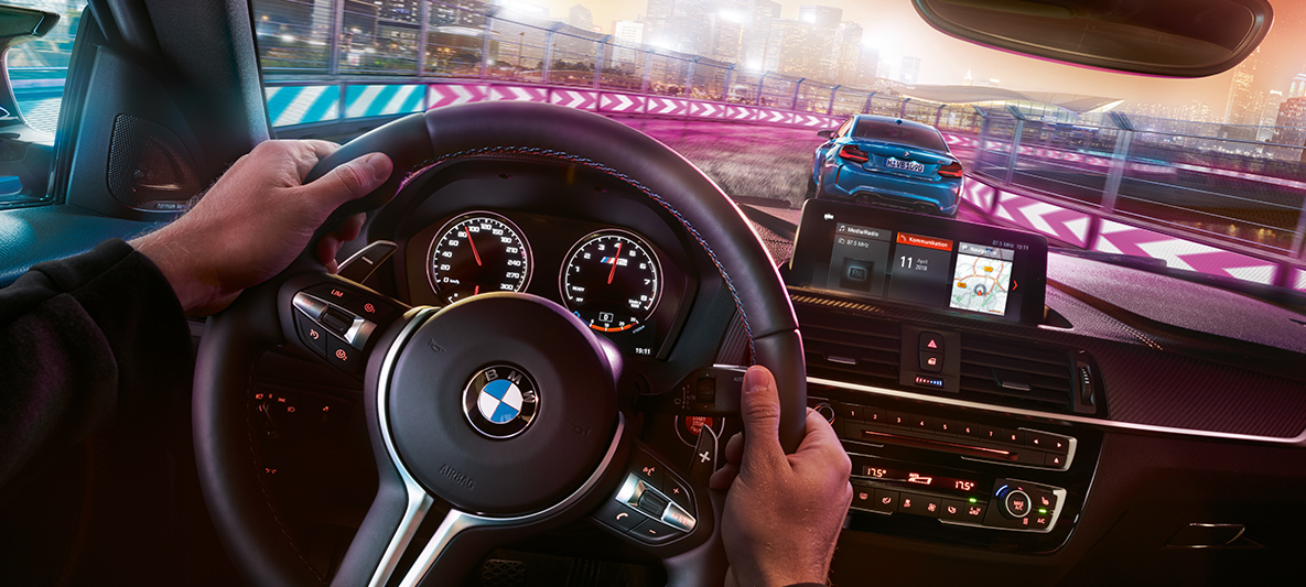 BMW M2 Competition kokpit Dva modela BMW M2 Competition u trkaćoj situaciji noću, pogled iz kokpita.