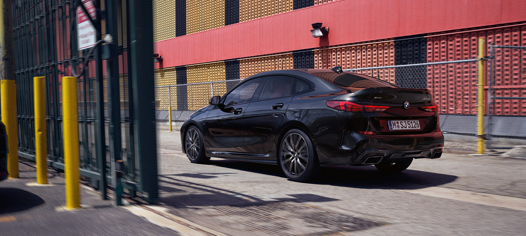 BMW M235i xDrive Gran Coupé F44 tročetvrtinski pogled straga u vožnji BMW M235i xDrive Gran Coupé F44 Black Sapphire metalik tročetvrtinski pogled straga u vožnji