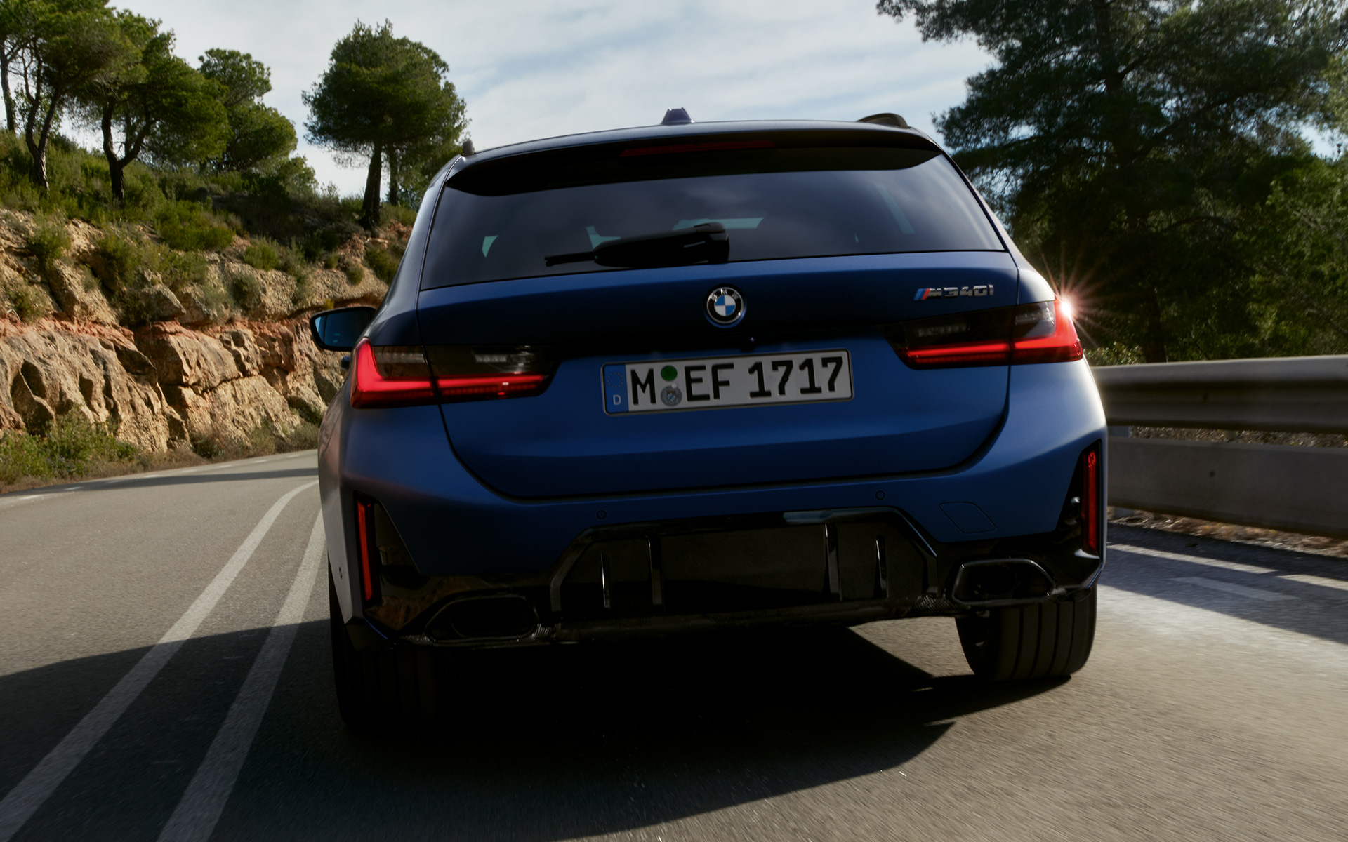 BMW M340i xDrive Touring G21 pogled straga u vožnji na cesti BMW M340i xDrive Touring G21 Frozen Tanzanite Blue pogled straga u vožnji na cesti