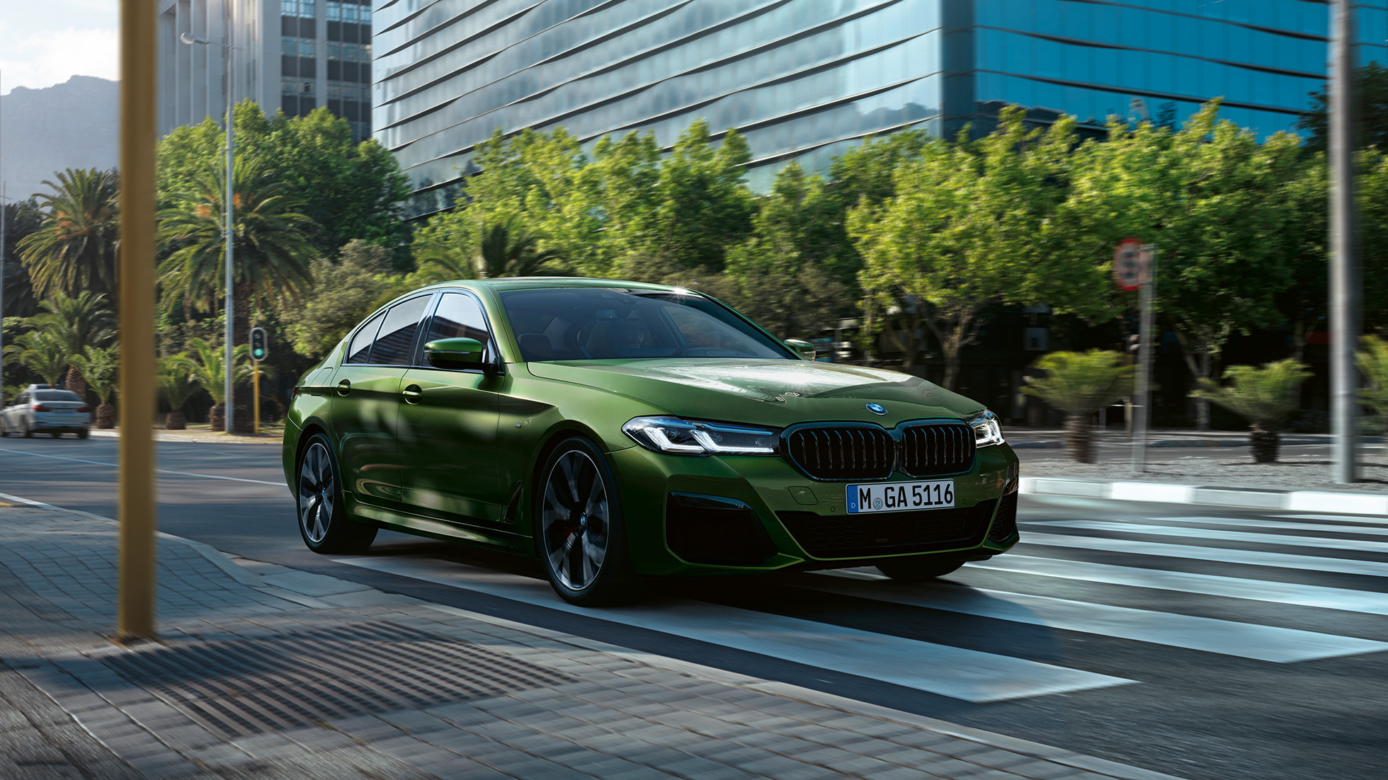 BMW M550i xDrive Limuzina G30 LCI Faceliftt 2020 tročetvrtinski prednji prikaz BMW M550i xDrive Limuzina G30 LCI Facelift BMW Individual Verde Ermes metalik tročetvrtinski prednji prikaz u vožnji