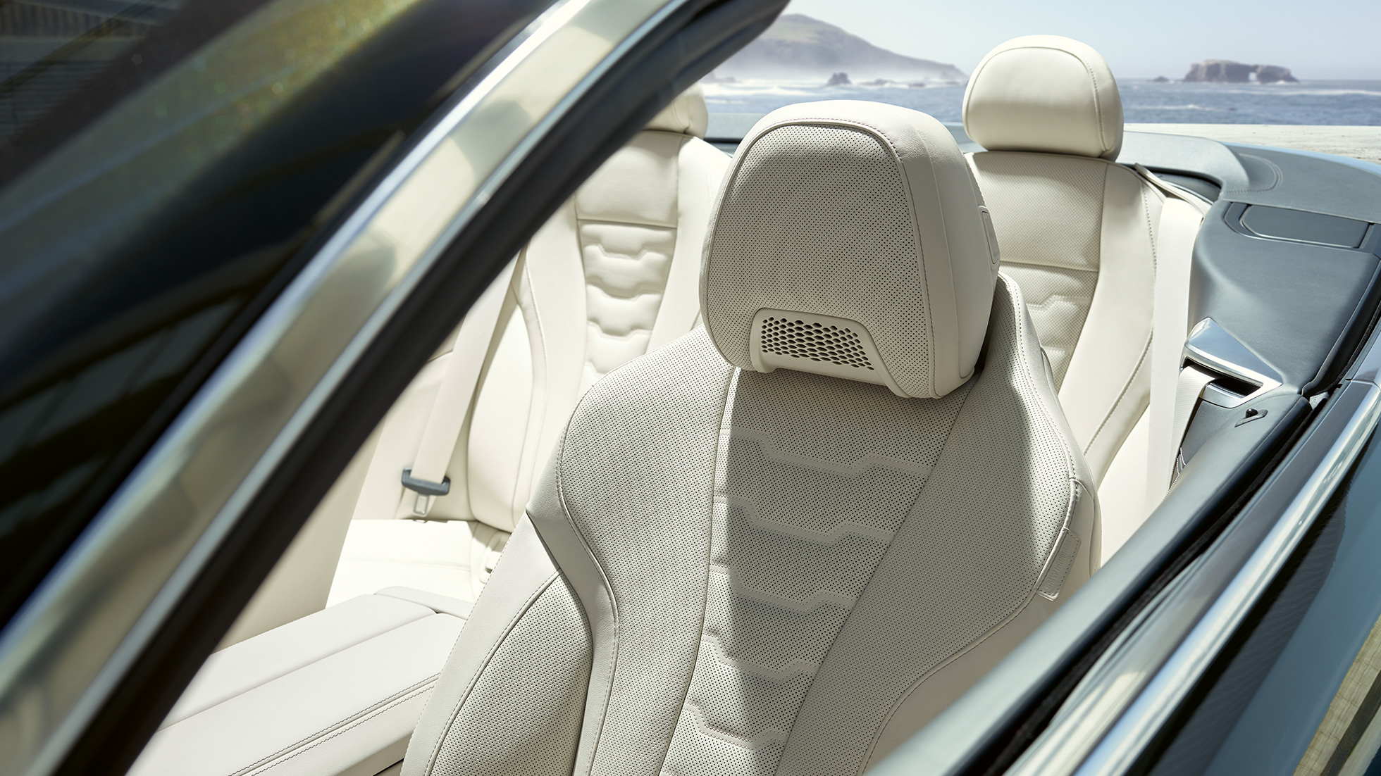 BMW M850i xDrive Cabrio, višenamjenska sjedala za vozača i suvozača. BMW M850i xDrive Cabrio u Dravit Grey metalik boji, sa spuštenim mekim krovom, unutrašnjost s višenamjenskim sjedalima u BMW Individual unutrašnjosti od 'Merino' kože u Ivory White boji.