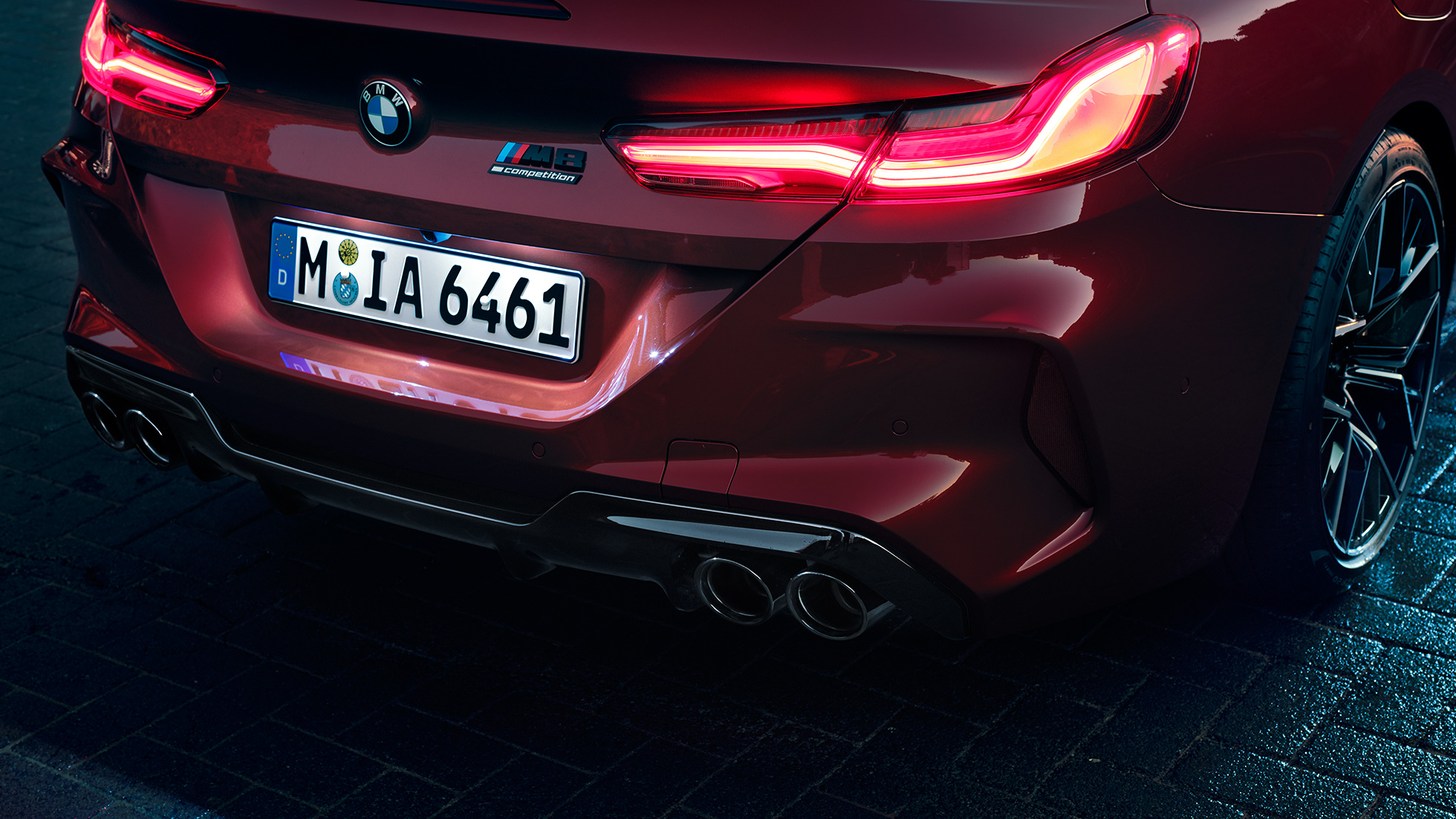 BMW M8 Competition Cabrio, detaljan prikaz stražnjeg kraja. BMW M8 Competition Cabrio u Motegi Red metalik boji, detaljan prikaz stražnjeg kraja sa stražnjim LED svjetlima i M8 Competition oznakom.