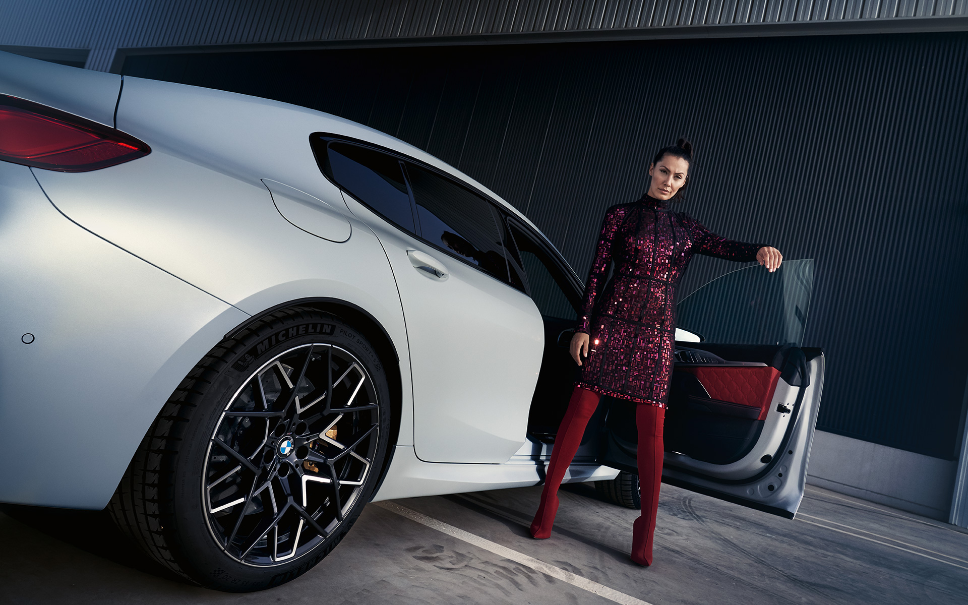 BMW M8 Competition Gran Coupé F93 LCI 2022 tročetvrtinski pogled straga sa modelom iz niskog kuta BMW M8 Competition Gran Coupé F93 LCI Facelift 2022 BMW Individual Frozen Brilliant White metalik tročetvrtinski pogled straga sa modelom iz niskog kuta
