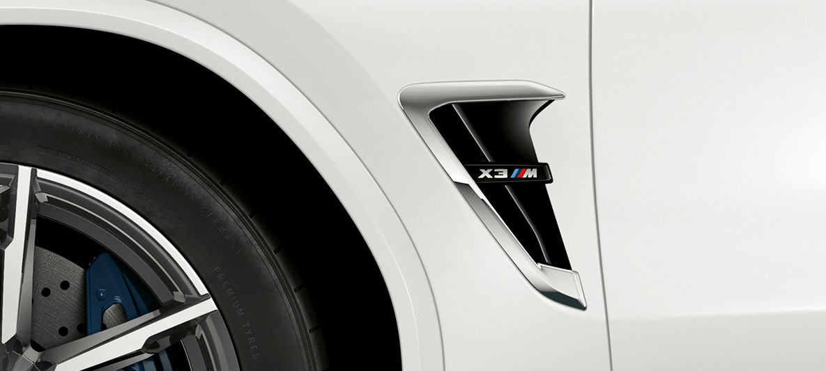 BMW X3 M, M škrge. BMW X3 M u Alpine White boji, vanjština, M škrga s kormiranim značajkama i oznakom modela.