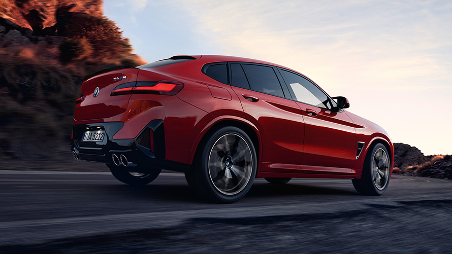 BMW X4 M F98 LCI Facelift 2021 Toronto Red metalik tročetvrtinski pogled straga u vožnji cestom