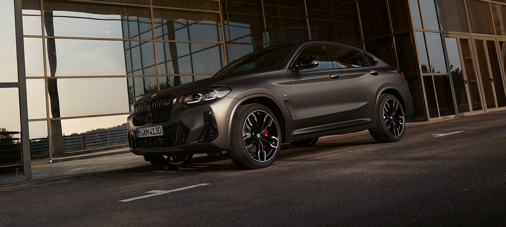 Tročetvrtinski pogled sprijeda BMW X4 M40i G02 LCI 2021 Facelift BMW X4 M40i G02 LCI 2021 Facelift tročetvrtinski pogled sprijeda ispred staklene fasade