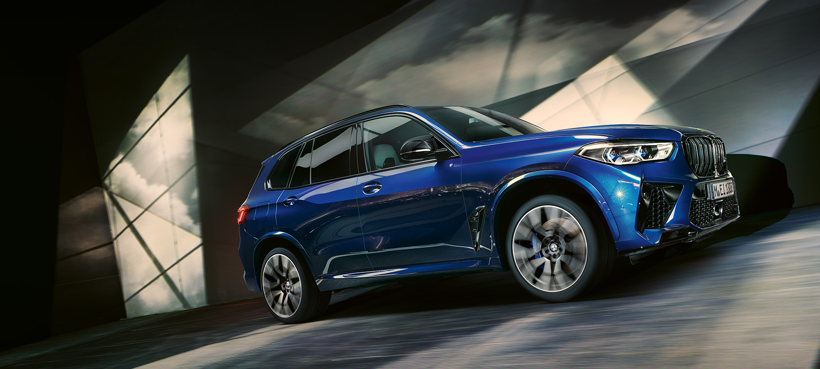 BMW X5 M Automobili F95 2020 SUV BMW X5 M Competition Marina Bay Blue metalik tročetvrtinski pogled s boka iz niskog kuta u vožnji