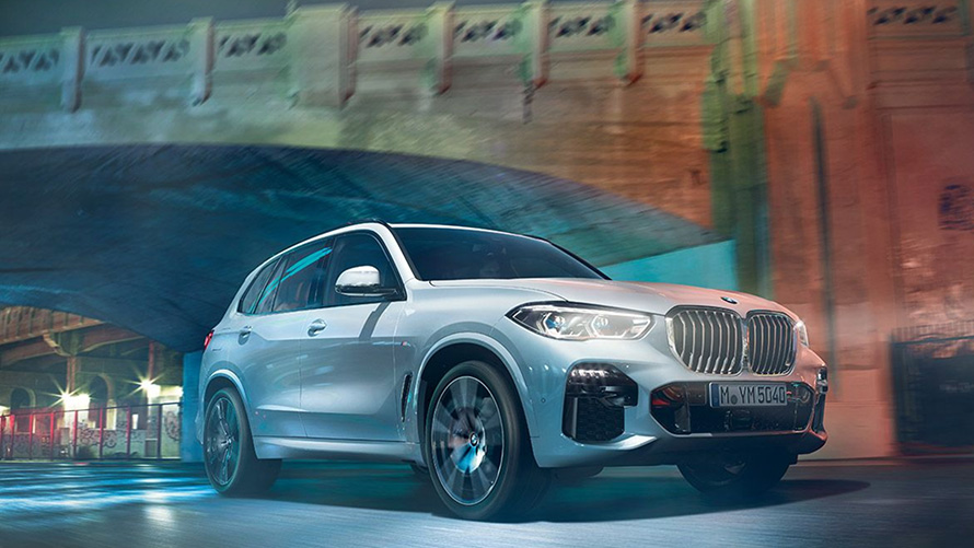 BMW X5 tročetvrtinski pogled sprijeda G05 BMW X5 G05 2018 SUV Mineral White metalik tročetvrtinski pogled sprijeda u vožnji noću