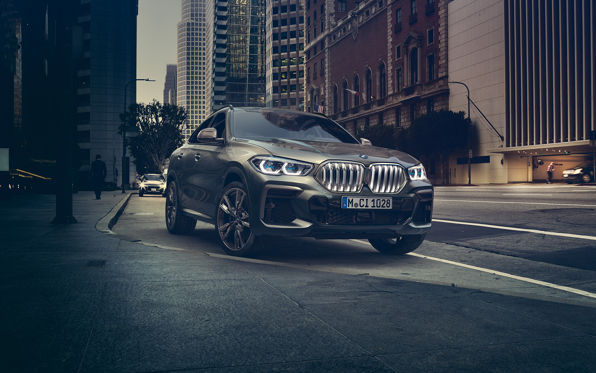 BMW X6 M50i u tročetvrtinskom pogledu sprijeda u mirovanju ispred urbane sredine G06 2018 SUV