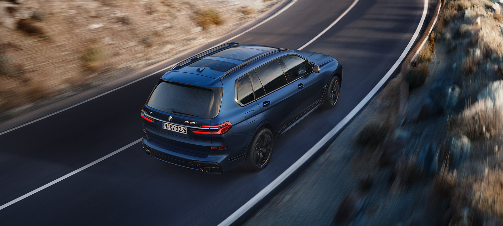 BMW X7 M60i xDrive G07 LCI Frozen Marina Bay Blue tročetvrtinski pogled straga iz ptičje perspektive u vožnji BMW X7 M60i xDrive G07 LCI Frozen Marina Bay Blue tročetvrtinski pogled straga iz ptičje perspektive u vožnji na ulici