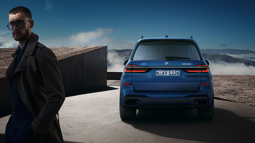 BMW X7 M60i xDrive G07 LCI Frozen Marina Bay Blue pogled straga u mirovanju ispred planinskog krajolika BMW X7 M60i xDrive G07 LCI Frozen Marina Bay Blue pogled straga u mirovanju ispred planinskog krajolika s modelom