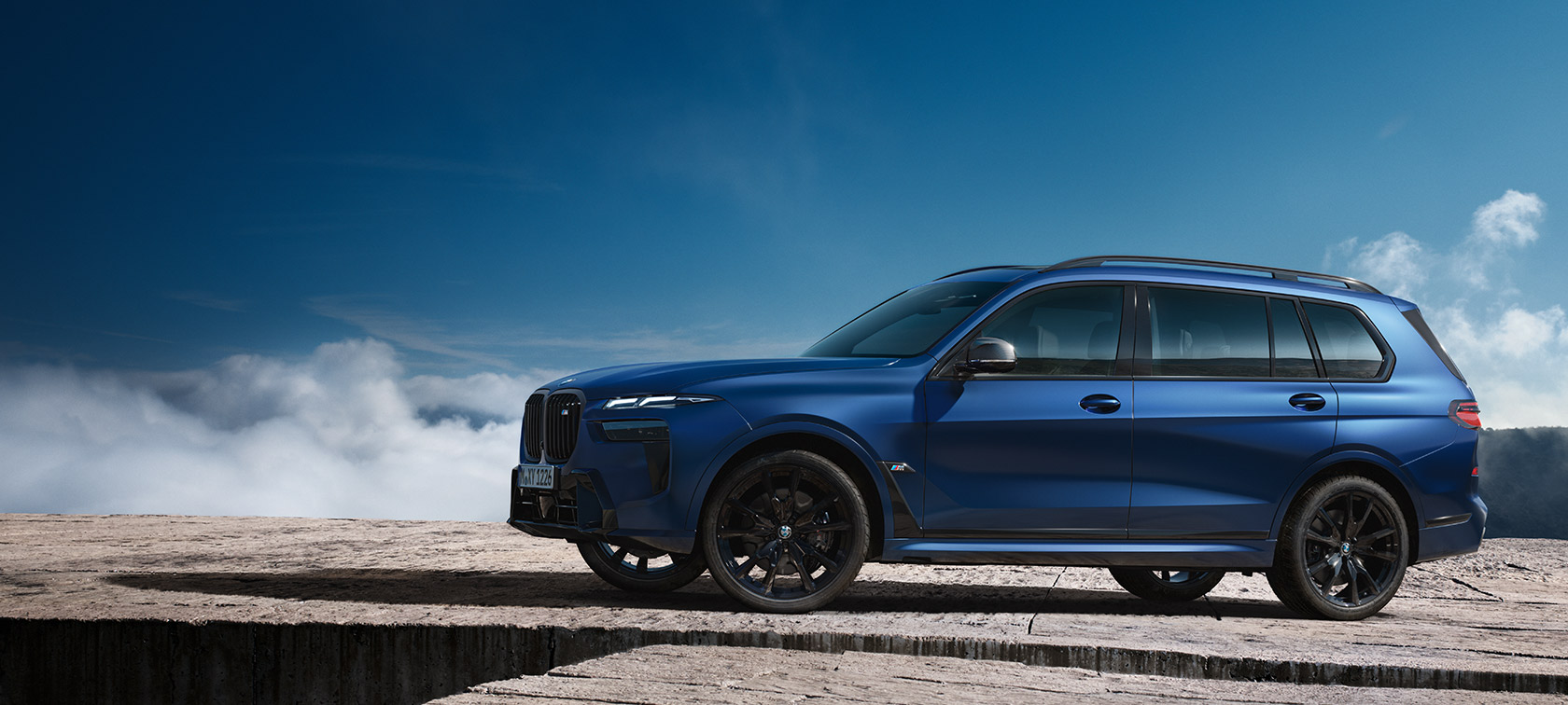 BMW X7 M60i xDrive G07 LCI Frozen Marina Bay Blue bočni pogled ispred planinskog krajolika
