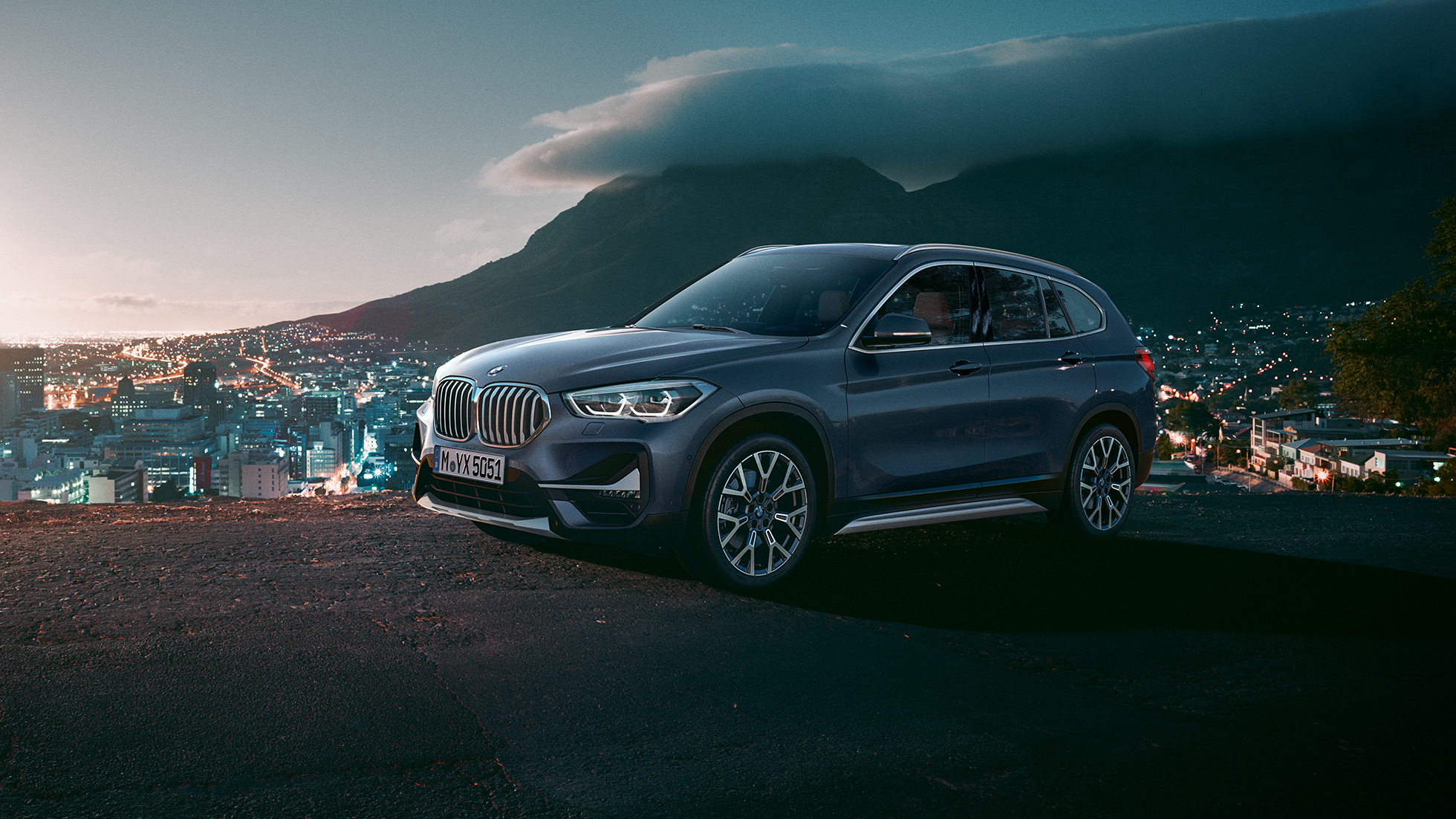 BMW X1, tročetvrtinski bočni prikaz. BMW X1, tročetvrtinski bočni prikaz automobila parkiranog ispred urbane sredine.