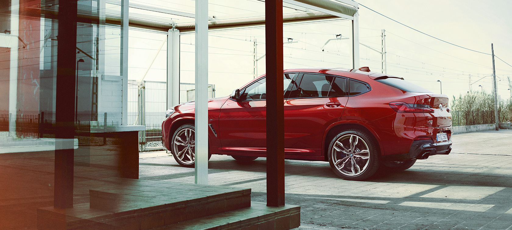 BMX X4 bočni pogled BMW X4 M40i G02 2018 Flamenco Red sa briljantnim efektom bočni pogled na parkingu