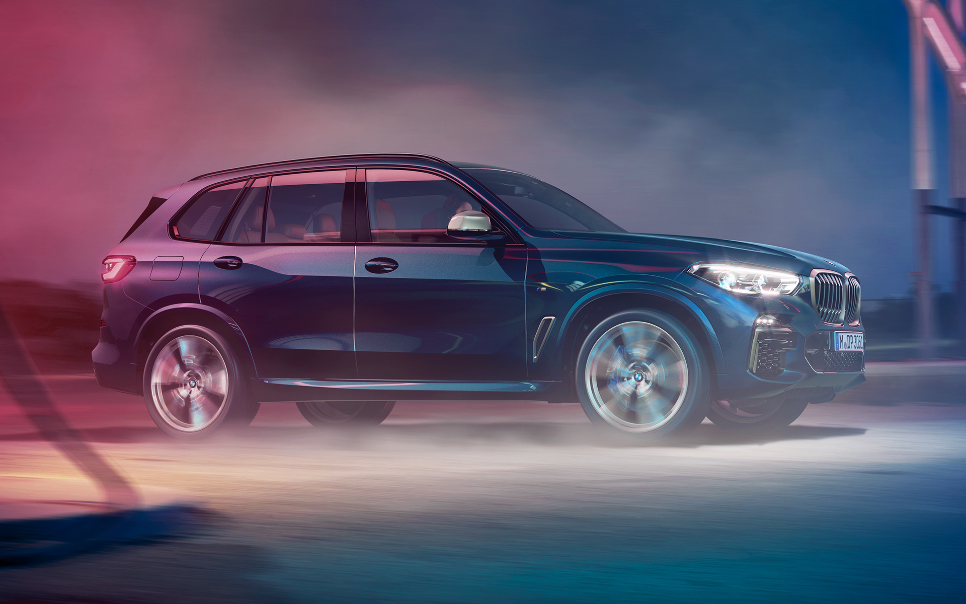 BMW X5 M50d u pokretu Prikaz vožnje BMW-a X5 M50d noću u urbanoj sredini