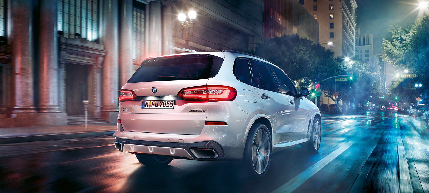 BMW X5 tročetvrtinski stražnji prikaz u vožnji BMW X5 G05 2018 Mineral White metalik tročetvrtinski stražnji prikaz u vožnji