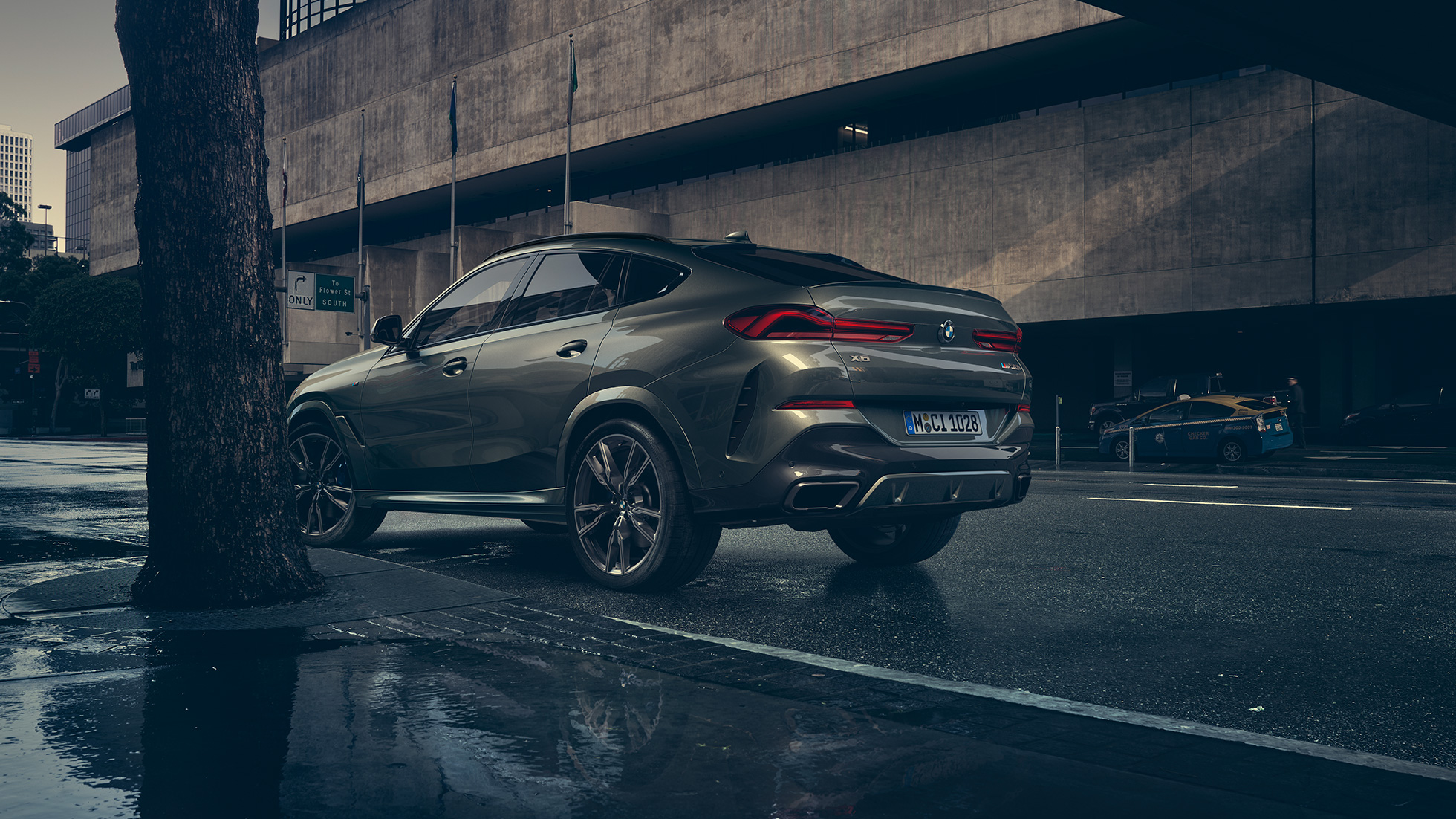 BMW X6 vanjština. BMW X6 iz stražnje tro-četvrtinske perspektive ispred urbanog okruženja.