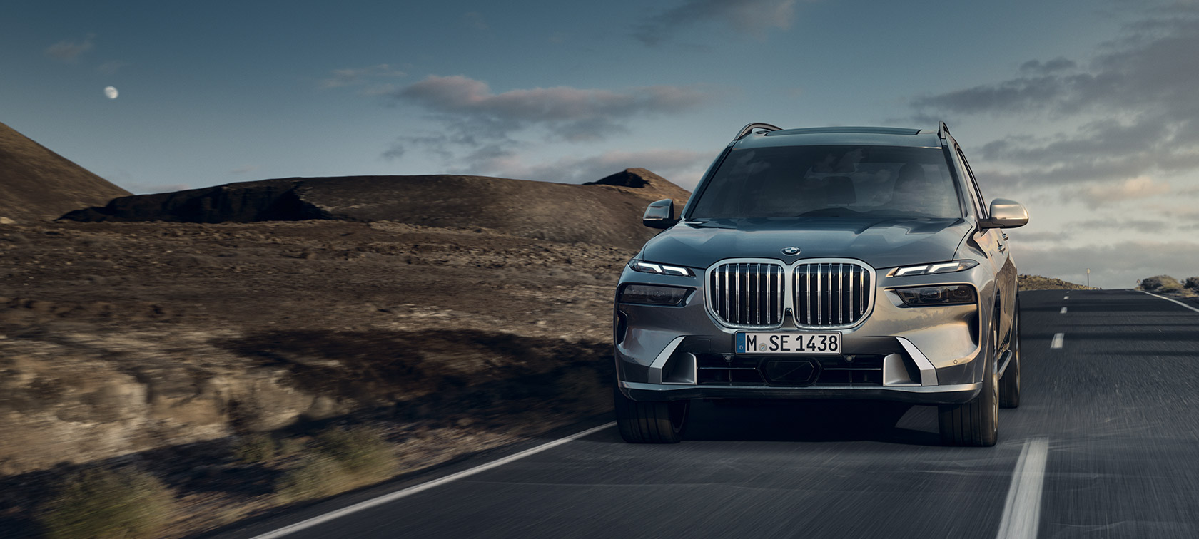 BMW X7 G07 LCI 7/8 pogled sprijeda u vožnji Sparkling Copper Grey metalik 