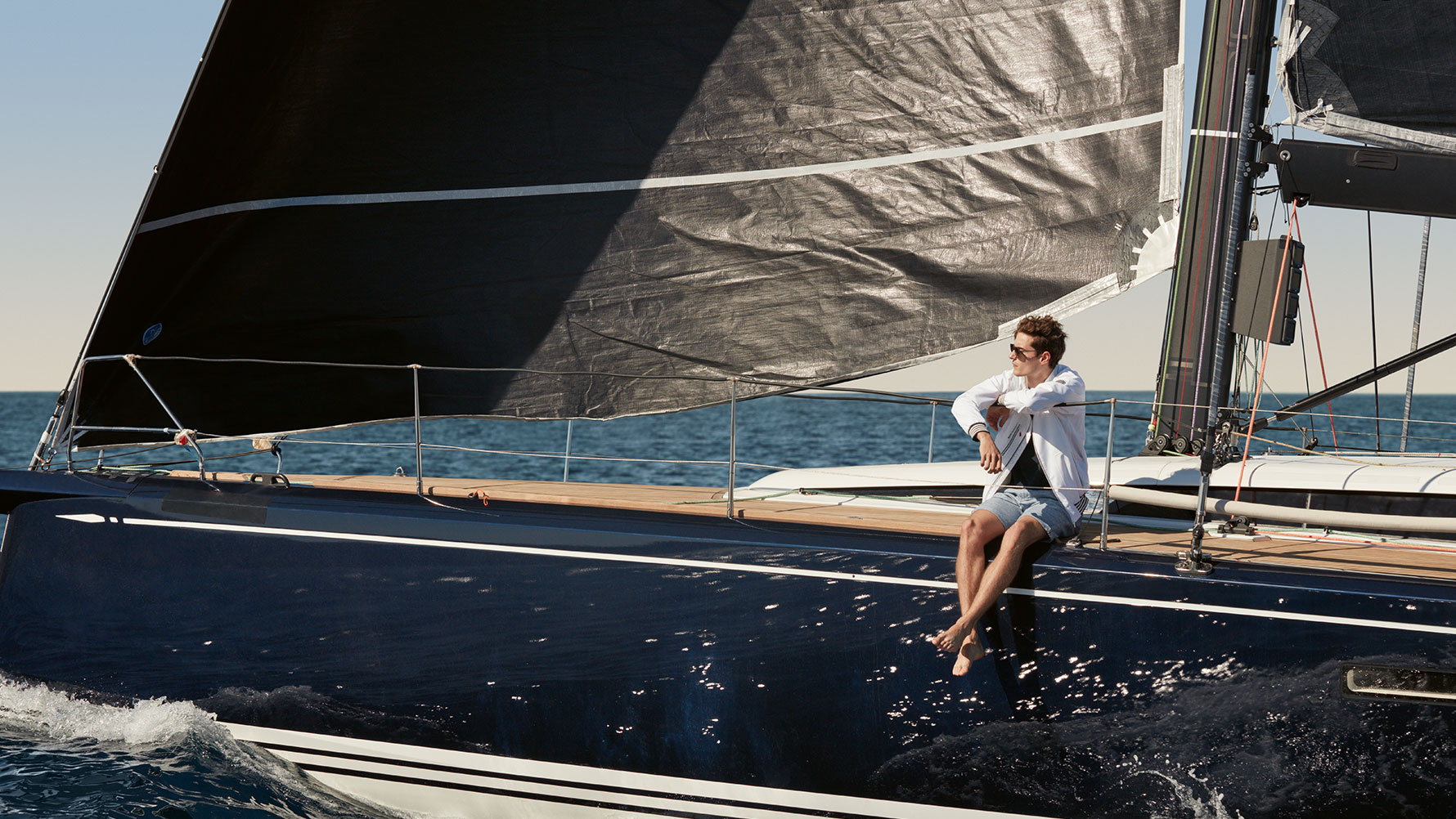 Muškarac sjedi na jahti i nosi mušku BMW Yachtsport jaknu iz BMW Yachtsport kolekcije. Muškarac sjedi na jahti i nosi mušku BMW Yachtsport jaknu iz BMW Yachtsport kolekcije.