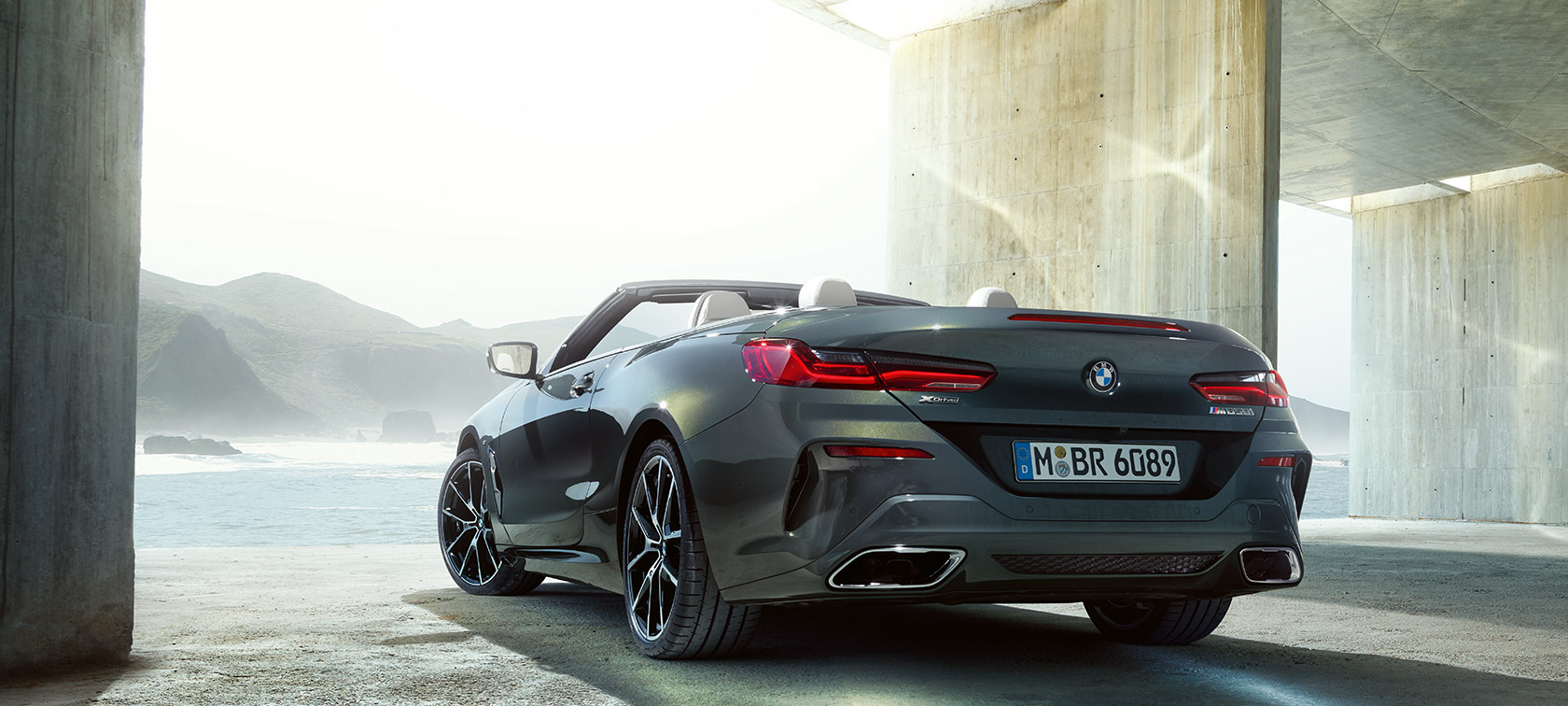 BMW M850i xDrive Dravit Grey metalik, stražnji lijevi tročetvrtinski prikaz.