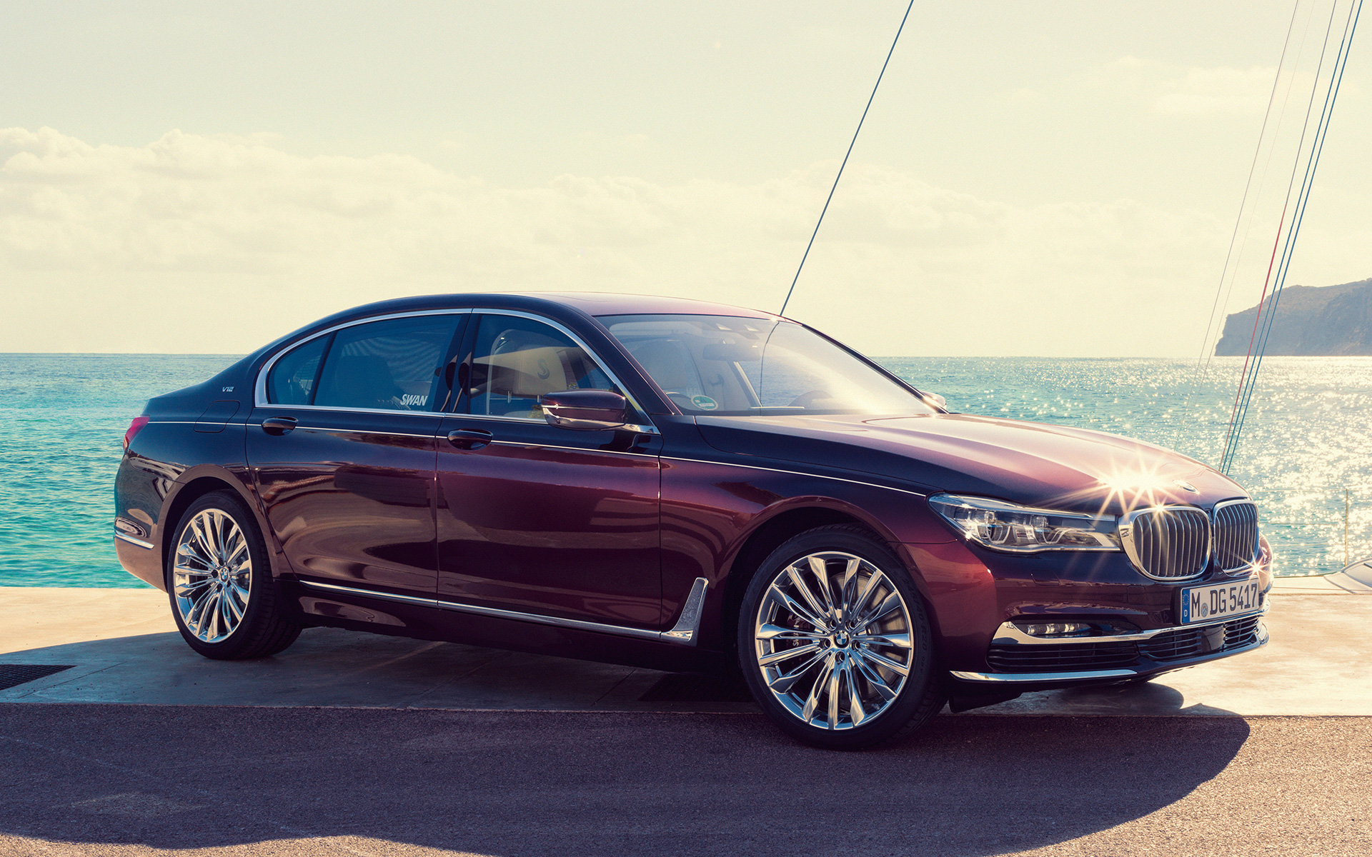 BMW Individual M760Li nadahnut od Nautor’s Swan G12 2017 ispred jedrilice u zaljevu BMW Individual M760Li nadahnut od Nautor’s Swan G12 2017 tročetvrtinski pogled s boka stoji na molu ispred jedrilice u zaljevu